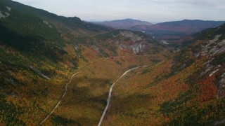 AX150_196 - 5.5K aerial stock footage flying over bright forest, Highway 302, autumn, overcast, White Mountains, New Hampshire