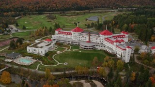 AX150_209E - 5.5K aerial stock footage orbiting Omni Mount Washington Resort, golf club, autumn, Carroll, New Hampshire
