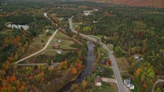AX150_219 - 5.5K aerial stock footage of Highway 302 through small rural town, Ammonoosuc River, autumn, Carroll, New Hampshire