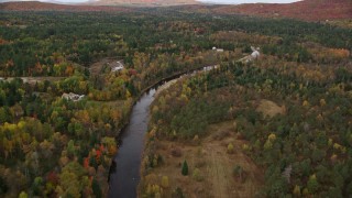 AX150_220E - 5.5K aerial stock footage flying over small rural town, Ammonoosuc River, autumn, Carroll, New Hampshire