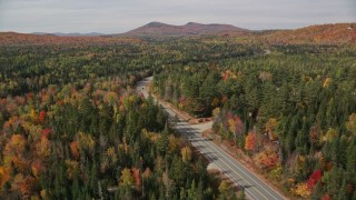 AX150_224E - 5.5K aerial stock footage flying over trees, foliage, approach Highway 302, autumn, Carroll, New Hampshire