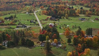 AX150_244E - 5.5K aerial stock footage flying by rural homes, colorful trees in autumn, Sugar Hill, New Hampshire
