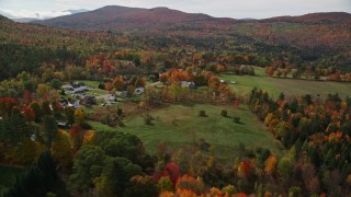 AX150_246E - 5.5K aerial stock footage approaching small rural town, colorful foliage, autumn, Sugar Hill, New Hampshire