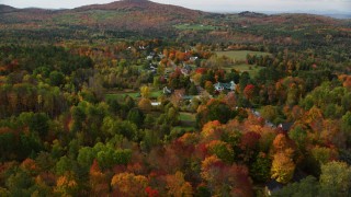 AX150_255 - 5.5K stock footage aerial video approaching a small rural town, colorful foliage in autumn, Sugar Hill, New Hampshire