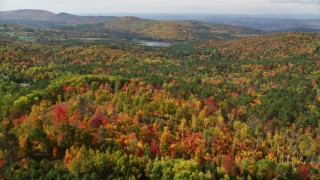 AX150_259 - 5.5K aerial stock footage flying over colorful forest, approaching Pearl Lake, autumn, Lisbon, New Hampshire