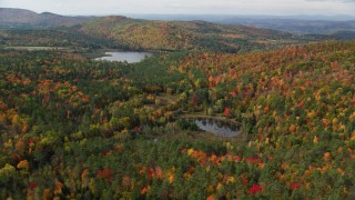 AX150_260 - 5.5K aerial stock footage flying over a forest, approaching Pearl Lake, autumn, Lisbon, New Hampshire