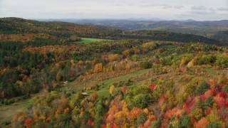 AX150_262 - 5.5K aerial stock footage flying over forest of brightly colored trees, autumn, Lisbon, New Hampshire