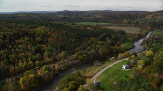 AX150_267 - 5.5K aerial stock footage flying over rural homes, Ammonoosuc River, approach farm, autumn, Lisbon, New Hampshire