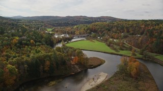 AX150_270E - 5.5K aerial stock footage tilt to reveal Ammonoosuc River, approach small town, autumn, Bath, New Hampshire