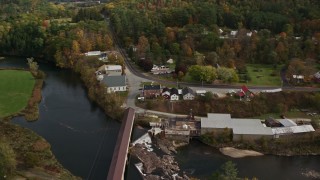 AX150_273E - 5.5K aerial stock footage orbiting rural town, covered bridge, church, Ammonoosuc River, autumn, Bath, New Hampshire