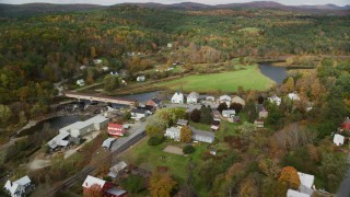 AX150_275 - 5.5K aerial stock footage orbiting a rural town on the Ammonoosic River, in autumn, Bath, New Hampshire