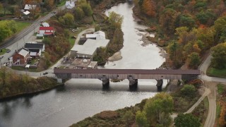AX150_276E - 5.5K aerial stock footage orbiting bridge spanning Ammonoosuc River, rural town, autumn, Bath, New Hampshire
