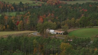 AX150_281 - 5.5K aerial stock footage flying by an isolated home and colorful foliage in autumn, Bath, New Hampshire