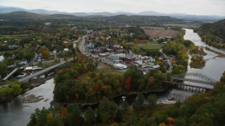 AX150_286 - 5.5K stock footage aerial video flying by rural town, bridge, Ammonoosuc River and Connecticut River, autumn, Woodsville, New Hampshire