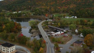 AX150_295 - 5.5K aerial stock footage approaching small town, Bath-Haverhill Bridge, Ammonoosuc River, autumn, Woodsville, New Hampshire