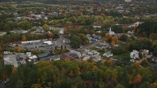 AX150_298E - 5.5K aerial stock footage of small rural towns, car dealership near Connecticut River, autumn, Wells River, Vermont