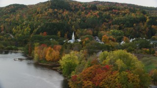 AX150_305 - 5.5K aerial stock footage approaching and flying by a church in a small town in autumn, Wells River, Vermont
