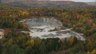 AX150_307 - 5.5K aerial stock footage approaching a small quarry, colorful trees in autumn, tilt down, Wells River, Vermont