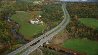 AX150_309 - 5.5K aerial stock footage approaching a small bridge, Interstate 91 across a small river, autumn, Wells River, Vermont