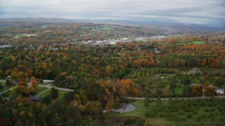 AX150_342 - 5.5K aerial stock footage approaching and flying over rural homes, colorful trees in autumn, Barre, Vermont
