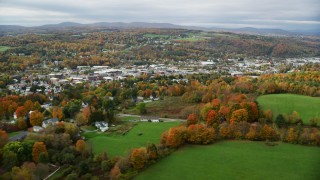 AX150_344 - 5.5K aerial stock footage flying by homes, colorful foliage, downtown, autumn, Barre, Vermont