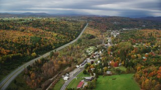 AX150_347 - 5.5K stock footage aerial video flying over Route 62, Main Street, approach rural homes, forest in autumn, Barre, Vermont