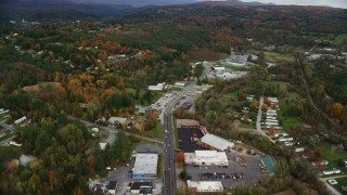 AX150_350 - 5.5K aerial stock footage flying over strip malls, car dealership on Main Street, colorful trees, autumn, Barre, Vermont