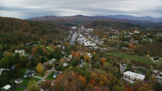 AX150_352 - 5.5K aerial stock footage flying over homes, approach small bridge, Winooski River, autumn, Montpelier, Vermont