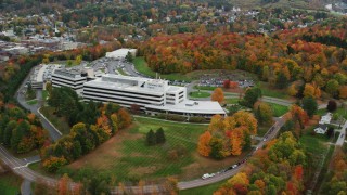 AX150_365 - 5.5K aerial stock footage orbiting large office buildings, grassy clearings, trees in autumn,  Montpelier, Vermont