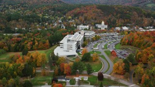 AX150_366 - 5.5K aerial stock footage orbiting grassy clearings, colorful trees, office buildings, autumn, Montpelier, Vermont