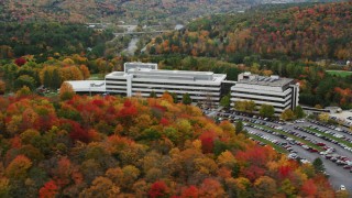 AX150_368 - 5.5K aerial stock footage orbiting brightly colored trees, large office buildings, autumn, Montpelier, Vermont