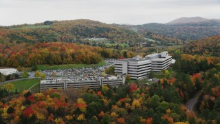AX150_370 - 5.5K aerial stock footage orbiting office buildings, overcast skies, colorful trees, autumn, Montpelier, Vermont