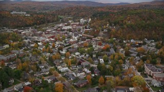 AX150_378E - 5.5K aerial stock footage flying by residential neighborhoods, colorful trees, and downtown in autumn, Montpelier, Vermont