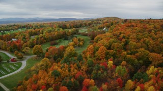 AX150_406 - 5.5K aerial stock footage flying by a cemetery, colorful trees, cloudy sky in autumn, Randolph Center, Vermont