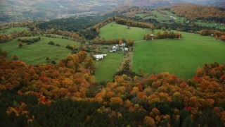 AX150_410 - 5.5K aerial stock footage approaching Silloway Road, farms, colorful trees in autumn Randolph Center, Vermont