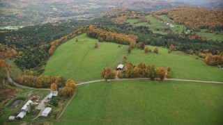 AX150_410E - 5.5K aerial stock footage approaching Silloway Road, farms, colorful trees in autumn Randolph Center, Vermont