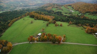 AX150_411 - 5.5K aerial stock footage flying by farms, Silloway Road, grassy clearings, foliage, autumn, Randolph Center, Vermont