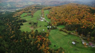 AX150_412 - 5.5K aerial stock footage flying by farms, Davis Road, colorful trees, autumn, Randolph Center, Vermont