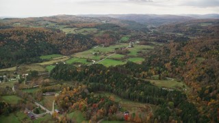 AX150_415E - 5.5K aerial stock footage flying over Route 14, Randolph Center Road and farms in autumn, Bethel, Vermont