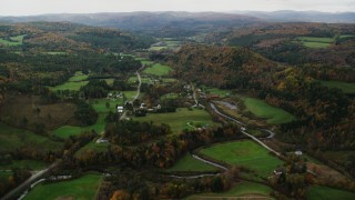 AX150_417 - 5.5K aerial stock footage flying over Route 14, farms, rural homes and small town, autumn, Bethel, Vermont
