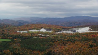 AX150_419 - 5.5K aerial stock footage flying by a colorful forest, quarry, autumn, overcast, Bethel, Vermont