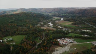 AX150_423 - 5.5K stock footage aerial video flying over trailers, approaching White River, Route 107 in autumn, South Royalton, Vermont