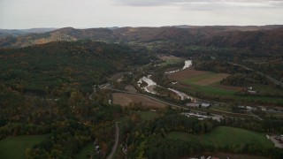 AX150_423E - 5.5K aerial stock footage flying over trailers, approaching White River, Route 107 in autumn, South Royalton, Vermont