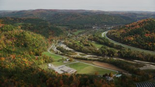 AX150_426 - 5.5K stock footage aerial video flying over forest, small farms, approach Route 14, White River, autumn, South Royalton, Vermont