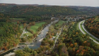 AX150_427 - 5.5K stock footage aerial video flying over White River, small farms, approach small rural town, autumn, South Royalton, Vermont