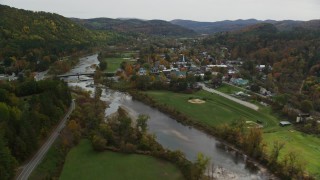 AX150_428 - 5.5K aerial stock footage flying by small bridge, White River, small rural town, autumn, South Royalton, Vermont