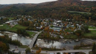 AX150_429 - 5.5K stock footage aerial video orbiting small bridge, White River, small rural town, autumn, South Royalton, Vermont