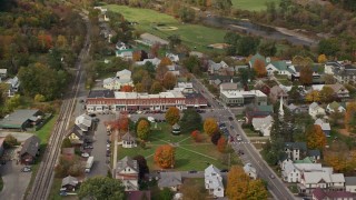 AX150_432 - 5.5K stock footage aerial video orbiting shops and town square in a small town, autumn, South Royalton, Vermont