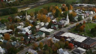 AX150_433 - 5.5K stock footage aerial video orbiting homes, churches in a small town, autumn, South Royalton, Vermont