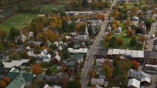 AX150_433E - 5.5K aerial stock footage orbiting homes, churches in a small town, autumn, South Royalton, Vermont